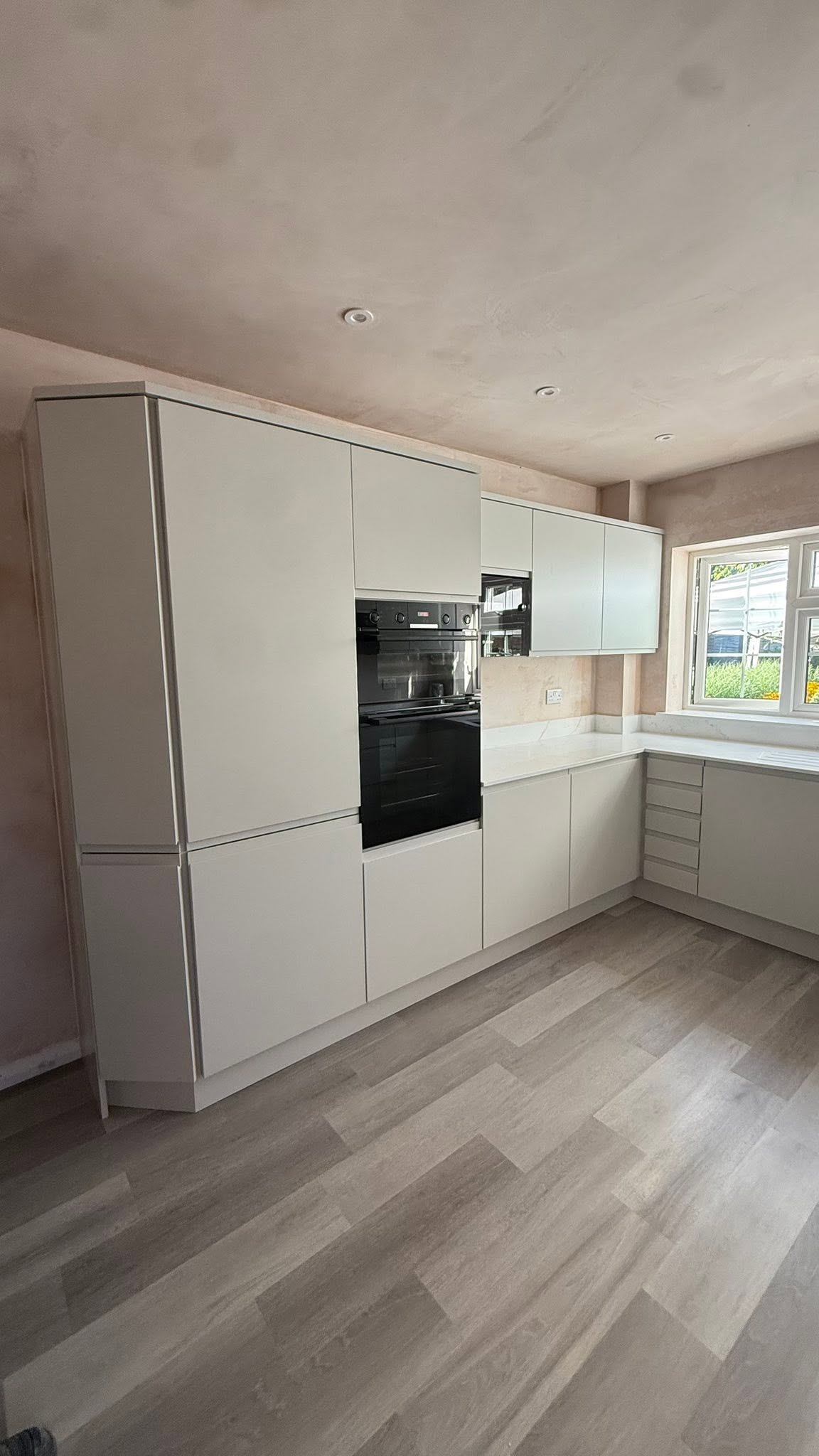 Light grey kitchen with tall units and a built-in oven, Kenilworth