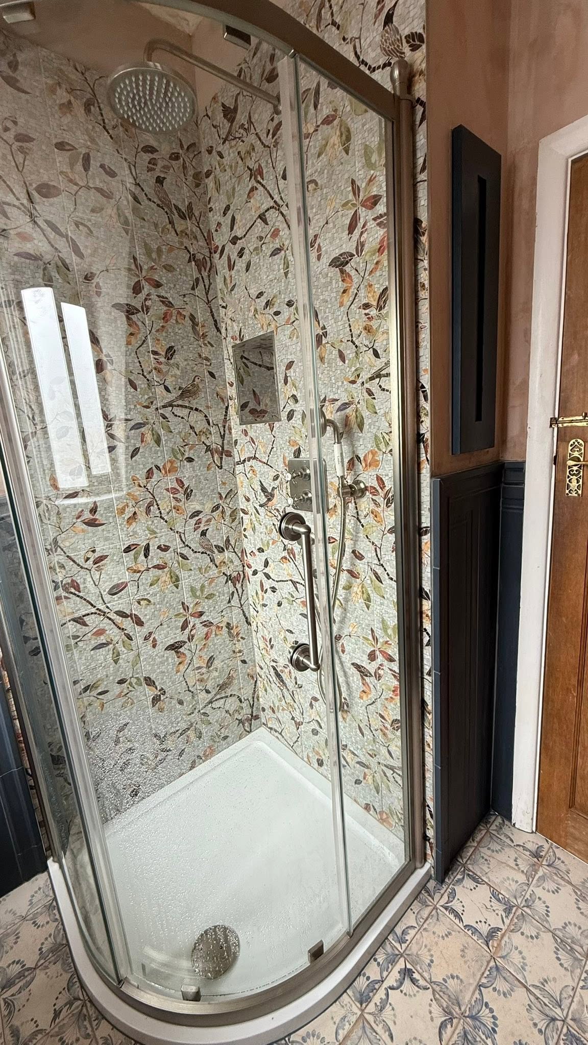 Quadrant shower enclosure with leaf-pattern tiles